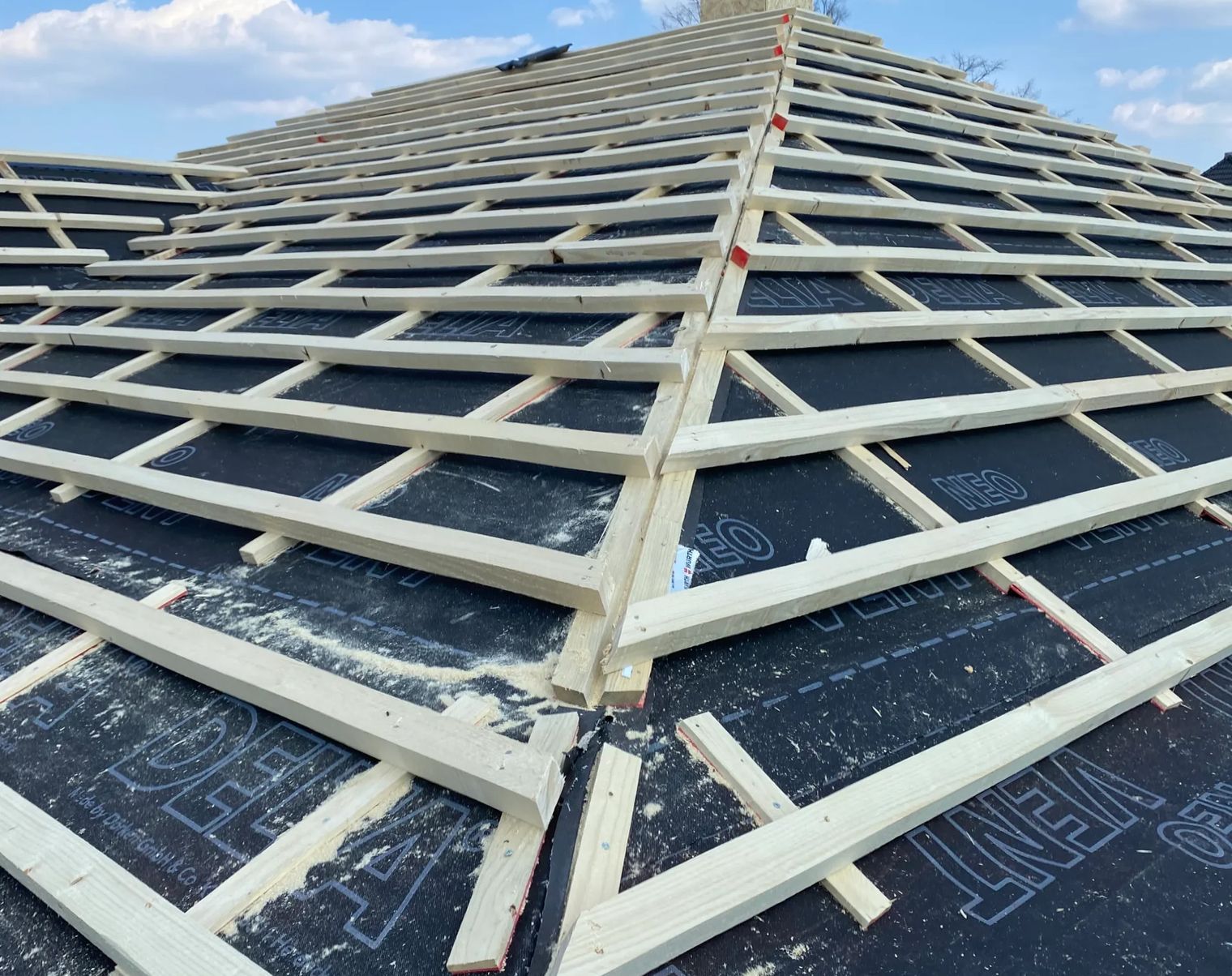 Ansicht einer Dachkonstruktion mit Holzrahmen und schwarzer Unterlage.