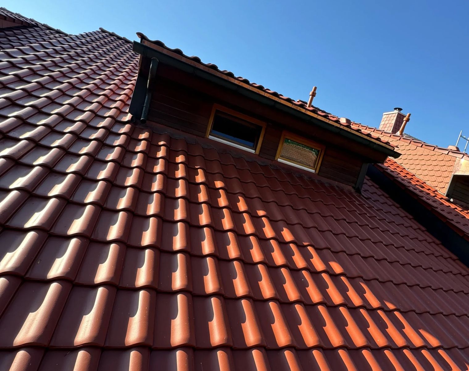 Ansicht eines roten Daches mit Ziegeln unter blauem Himmel
