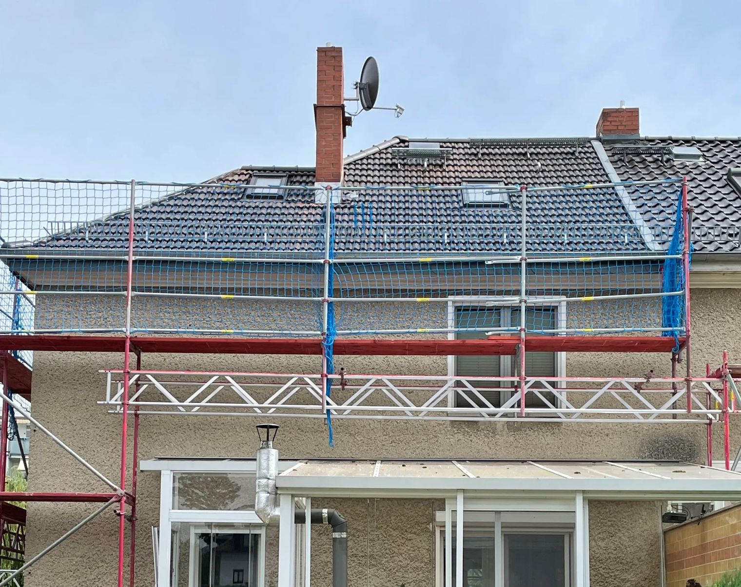Renovierung des Dachs mit Gerüst und Satellitenschüssel